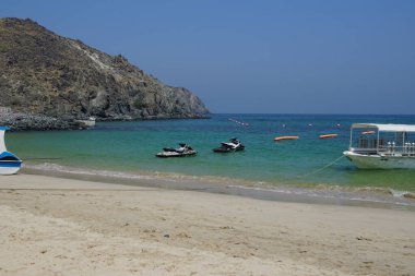 Khor Fakkan, Sharjah, BAE - 21 Nisan 2023: PWC ve diğer yüzey taşıma gemileri Khor Fakkan Sahili 'nde Umman Körfezi' nin sularındalar. Kişisel su aracı, PWC, su motosikleti, bir su gemisidir..                                