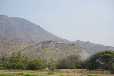 Nisan ayında Khor Fakkan, Sharjah, BAE 'deki Al Rabi Kulesi ve dağların manzarası.