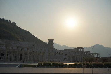 Khor Fakkan, Sharjah, BAE - 24 Nisan 2023: Güneş Nisan akşamı Hurfakkan Amfitiyatrosunun üzerinde parlıyor. Hurfakkan Amfitiyatrosu, Khor Fakkan 'da bulunan Şeriat Emirliği' nin açık hava tiyatrosu ve kültürel simgesidir.. 