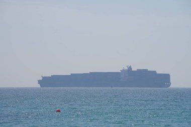 Khor Fakkan, Sharjah, BAE - 24 Nisan 2023: Khor Fakkan kıyısı boyunca Umman Körfezi 'ndeki limandan konteyner gemisi kalkıyor. 