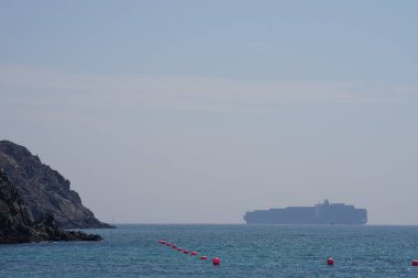 Khor Fakkan, Sharjah, BAE - 24 Nisan 2023: Khor Fakkan kıyısı boyunca Umman Körfezi 'ndeki limandan konteyner gemisi kalkıyor. 