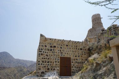 Nisan ayında gözlem kulesi ve eski Najd Al Miqsar köyü ile kalenin manzarası. Najd Al Miqsar, Khor Fakkan 'ın batısında, BAE' nin başkenti Sharjah 'ta terk edilmiş tarihi bir yerleşim yeridir.. 