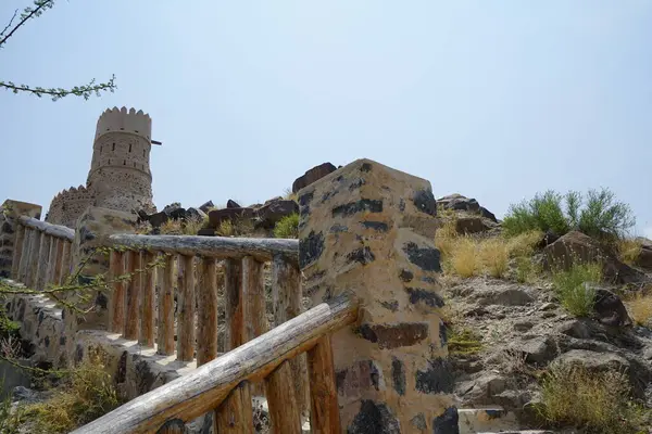 Nisan ayında gözlem kulesi ve eski Najd Al Miqsar köyü ile kalenin manzarası. Najd Al Miqsar, Khor Fakkan 'ın batısında, BAE' nin başkenti Sharjah 'ta terk edilmiş tarihi bir yerleşim yeridir.. 