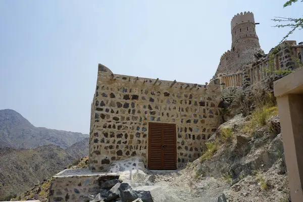 Nisan ayında gözlem kulesi ve eski Najd Al Miqsar köyü ile kalenin manzarası. Najd Al Miqsar, Khor Fakkan 'ın batısında, BAE' nin başkenti Sharjah 'ta terk edilmiş tarihi bir yerleşim yeridir.. 