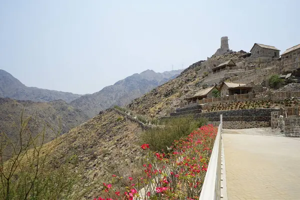 Nisan ayında gözlem kulesi ve eski Najd Al Miqsar köyü ile kalenin manzarası. Najd Al Miqsar, Khor Fakkan 'ın batısında, BAE' nin başkenti Sharjah 'ta terk edilmiş tarihi bir yerleşim yeridir.. 