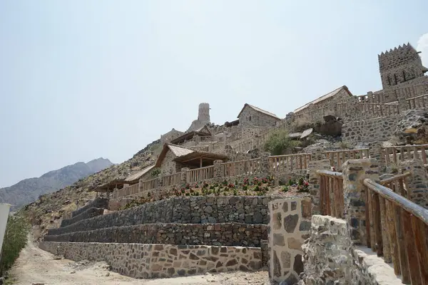 Nisan ayında gözlem kulesi ve eski Najd Al Miqsar köyü ile kalenin manzarası. Najd Al Miqsar, Khor Fakkan 'ın batısında, BAE' nin başkenti Sharjah 'ta terk edilmiş tarihi bir yerleşim yeridir.. 