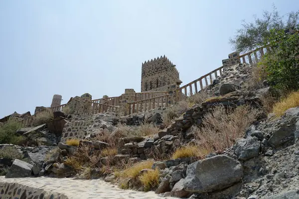 Nisan ayında gözlem kulesi ve eski Najd Al Miqsar köyü ile kalenin manzarası. Najd Al Miqsar, Khor Fakkan 'ın batısında, BAE' nin başkenti Sharjah 'ta terk edilmiş tarihi bir yerleşim yeridir.. 