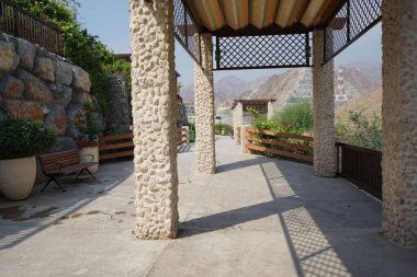 Güneş gözlükleri ve banklar, Hawd al Bid 'ah rezervuarının yakınındaki Al Rafisah Barajı dinlenme alanına kurulur. Wadi Wshee, Sharjah, BAE. 