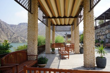 Güneş gözlükleri ve banklar, Hawd al Bid 'ah rezervuarının yakınındaki Al Rafisah Barajı dinlenme alanına kurulur. Wadi Wshee, Sharjah, BAE. 