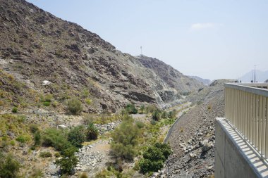 El Rafisah Barajı 'ndaki Hawd al Bid' ah rezervuarının çevresinde güzel bir dağ manzarası bulunur. Wadi Wshee, Sharjah, BAE. 