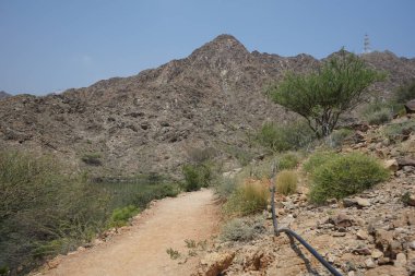 El Rafisah Barajı 'ndaki Hawd al Bid' ah rezervuarının çevresinde güzel bir dağ manzarası bulunur. Wadi Wshee, Sharjah, BAE. 