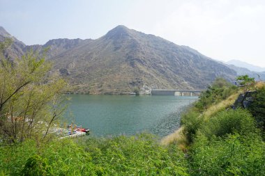 Al-Bid 'ah rezervuarı ve Al-Rafisah Barajı' ndaki Nisan ayındaki bitki örtüsü ile pitoresk bir sahilden Al-Khor Kayık tekne istasyonu manzarası. Wadi Wshee, Sharjah, BAE. 