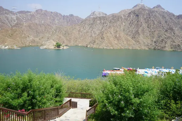 Al-Bid 'ah rezervuarı ve Al-Rafisah Barajı' ndaki Nisan ayındaki bitki örtüsü ile pitoresk bir sahilden Al-Khor Kayık tekne istasyonu manzarası. Wadi Wshee, Sharjah, BAE. 