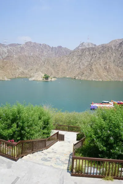 Al-Bid 'ah rezervuarı ve Al-Rafisah Barajı' ndaki Nisan ayındaki bitki örtüsü ile pitoresk bir sahilden Al-Khor Kayık tekne istasyonu manzarası. Wadi Wshee, Sharjah, BAE. 