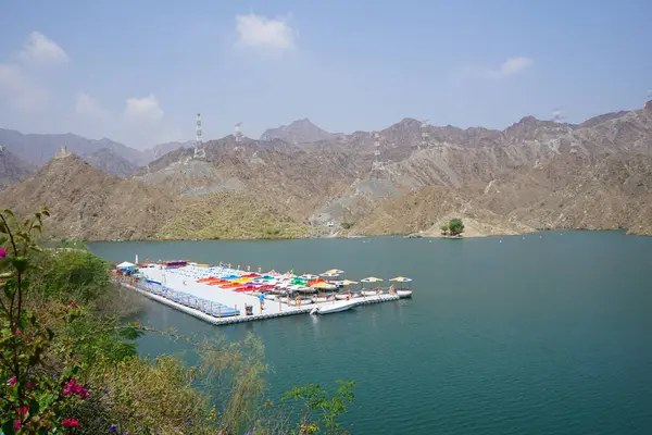 Al-Bid 'ah rezervuarı ve Al-Rafisah Barajı' ndaki Nisan ayındaki bitki örtüsü ile pitoresk bir sahilden Al-Khor Kayık tekne istasyonu manzarası. Wadi Wshee, Sharjah, BAE. 