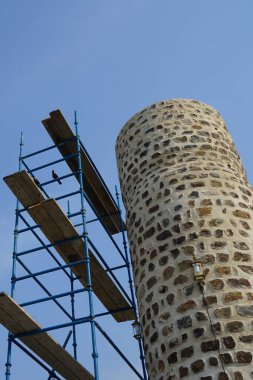 Corvus 'un görkemli kuşları Khor Fakkan' daki Al Adwani Kulesi civarında bulunur. Ev kargası, Corvus splendens, karga familyasının yaygın bir kuşudur. Sharjah, BAE.                                