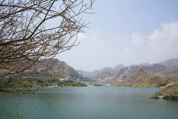 Nisan ayında El Rafisah Barajı 'nın dinlenme alanından dağlarla ve bitki örtüsüyle çevrili güzel Hawd al Bid' ah rezervuarının manzarası. Wadi Wshee, Sharjah, BAE. 