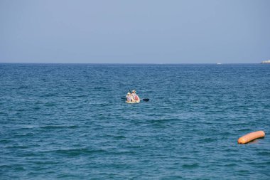 Khor Fakkan, Sharjah, BAE - 27 Nisan 2023: Nisan 'da Khor Fakkan Sahili yakınlarındaki Umman Körfezi' nde iki turist sarı bir kano ile kürek çekiyor.                           