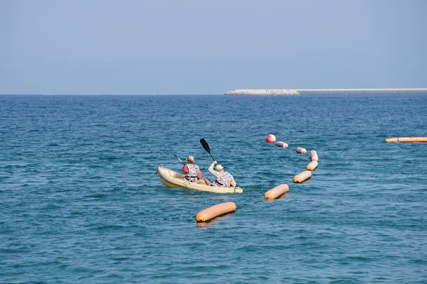 Khor Fakkan, Sharjah, BAE - 27 Nisan 2023: Nisan 'da Khor Fakkan Sahili yakınlarındaki Umman Körfezi' nde iki turist sarı bir kano ile kürek çekiyor.                           