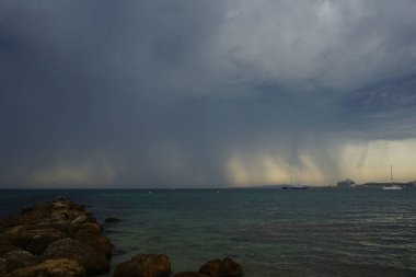 Suyla taşınan gemiler, yağmurun arkaplanına karşı Akdeniz 'de yol alıyorlar. Bir su aracı ya da su aracılığı ile seyahat etmek için tasarlanmış herhangi bir araçtır..                                