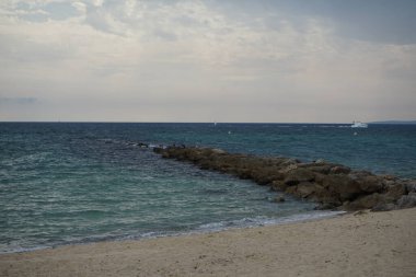 Phalacrocorax carbo ve Larus michahellis kuşları Eylül ayında Akdeniz yakınlarındaki dalgakıran kayalarında otururlar. Büyük karabatak olan Phalacrocorax carbo, karabatak familyasının yaygın bir üyesidir. Palma, Mallorca, İspanya.       