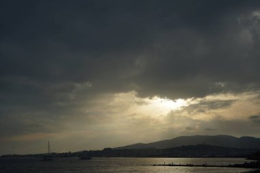 Güneş, İspanya 'nın Mallorca adasındaki Palma şehrindeki Akdeniz kıyısında bulutların arasından yükselir..                                   