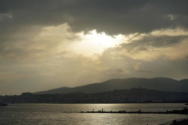 Güneş, İspanya 'nın Mallorca adasındaki Palma şehrindeki Akdeniz kıyısında bulutların arasından yükselir..                                   