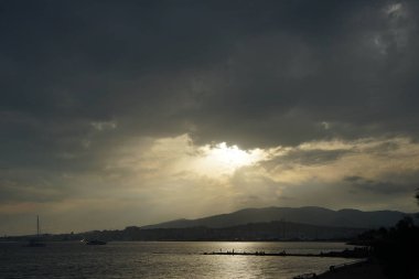 Güneş, İspanya 'nın Mallorca adasındaki Palma şehrindeki Akdeniz kıyısında bulutların arasından yükselir..                                   