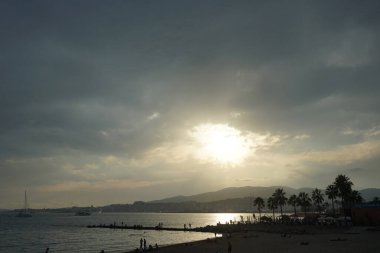 Palma, Mallorca, İspanya - 12 Eylül 2023: Güneş Akdeniz kıyısındaki Mallorca adasındaki Akdeniz kıyısında bulutların arasından yükseliyor.                                         