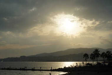 Güneş, İspanya 'nın Mallorca adasındaki Palma şehrindeki Akdeniz kıyısında bulutların arasından yükselir..                                   