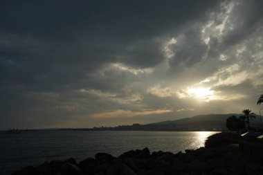Palma, Mallorca, İspanya - 12 Eylül 2023: Güneş Akdeniz kıyısındaki Mallorca adasındaki Akdeniz kıyısında bulutların arasından yükseliyor.                                         