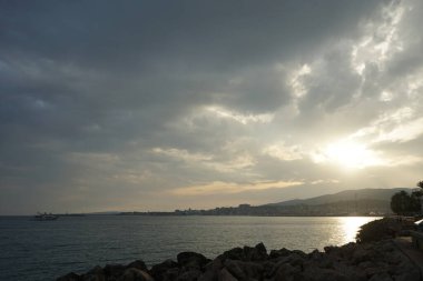 Palma, Mallorca, İspanya - 12 Eylül 2023: Güneş Akdeniz kıyısındaki Mallorca adasındaki Akdeniz kıyısında bulutların arasından yükseliyor.                                         