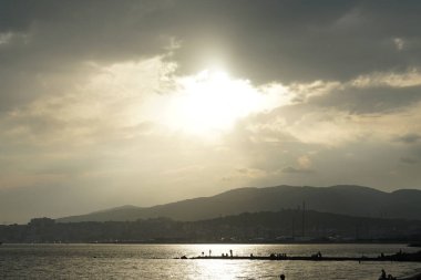 Güneş, İspanya 'nın Mallorca adasındaki Palma şehrindeki Akdeniz kıyısında bulutların arasından yükselir..                                