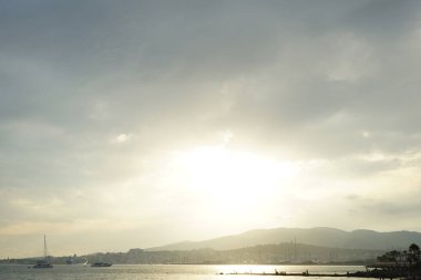 Güneş, İspanya 'nın Mallorca adasındaki Palma şehrindeki Akdeniz kıyısında bulutların arasından yükselir..                                