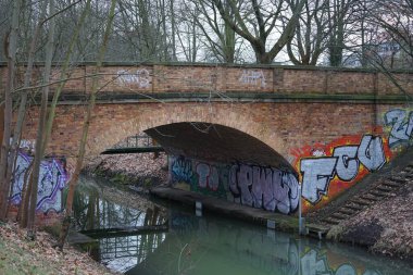 Berlin, Almanya, Avrupa - 12 Şubat 2023: Wuhle Nehri üzerinde bir taş ve metal köprü kuruldu.
