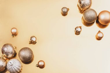 Altın arka planda Noel oyuncakları ve takılar. Kış tatili konsepti. Üst görünüm, düz görünüm, kopyalama alanı.