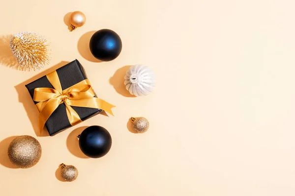 Чорна Подарункова Коробка Золотою Стрічкою Різдвяними Сукнями Бежевому Фоні Вид — стокове фото