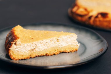 Siyah masadaki gri tabakta ev yapımı cheesecake, yakın plan..