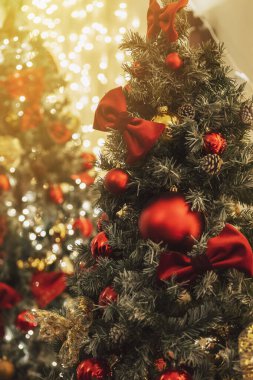 Kırmızı topları ve Noel ışıkları olan köknar ağacındaki şaşırtıcı Noel süslemeleri, bulanık arka plan.