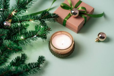 Noel arkaplanı mum, hediye kutusu, köknar dalları ve yeşil masada Noel oyuncakları. Üst görünüm.