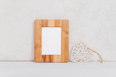 Sahte ahşap çerçeve ve beyaz kalbe karşı oyuncak kalp. Sevgililer Günü konsepti. Boşluğu kopyala.