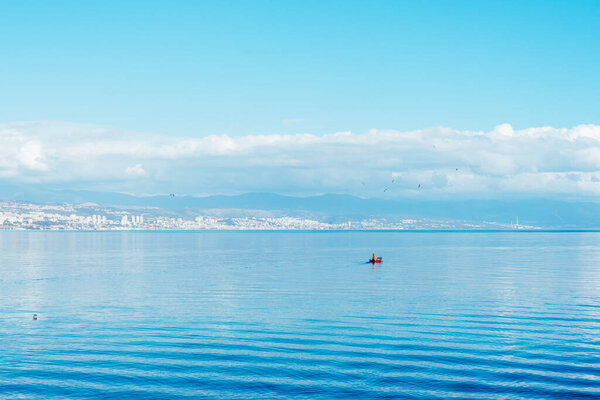 Beautiful blue sea with fishing boat. View of Rijeka city, Croatia.
