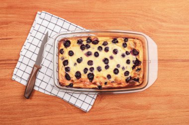 Homemade blueberry pie with knife and napkin on wooden table, top view. clipart