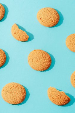 Mavi arka planda ev yapımı kurabiyeler ve keskin gölgeler. Üst manzara, düz uzanma.