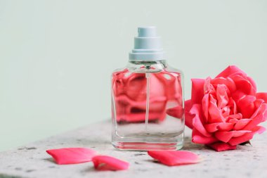 Cam parfüm şişesi ve mercan pembe gül çiçekleri..