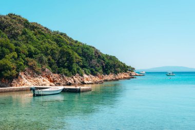 Mavi denizde bir tekne, sahilin arka planına karşı. Yaz tatili konsepti.