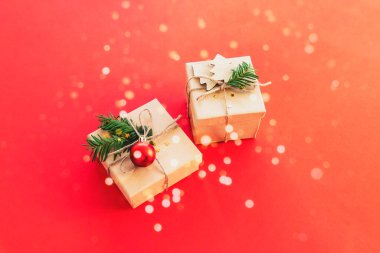 Kırmızı arka planda iki hediye kutusu ve altın konfeti. Noel konsepti. Üst görünüm.