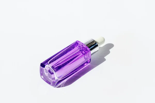 白い背景の堅い影が付いている紫色の化粧品の血清のびん トレンドのセルフケア製品 トップビュー — ストック写真