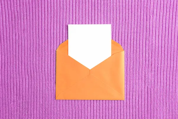 Orangefarbener Umschlag Mit Leerer Karte Auf Lila Strickstoff Hintergrund Geburtstag — Stockfoto