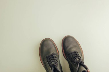 Açık yeşil arka planda son moda koyu yeşil çizmeler. Ayakkabı satışı, moda konsepti. Yürüyüş için şık ayakkabılar. Üst görünüm, düz görünüm, kopyalama alanı.